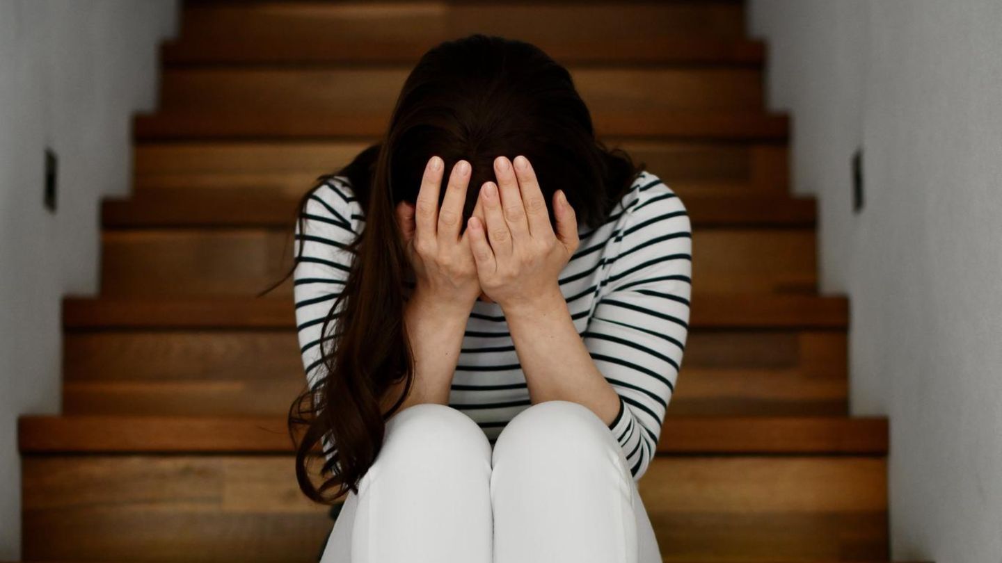 Eine Frau sitzt auf einer Treppe und ist verzweifelt