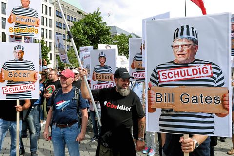 Demonstranten demonstrieren gegen Corona-Richtlinien mit Plakaten