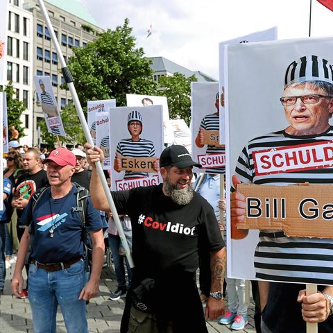 Demonstranten demonstrieren gegen Corona-Richtlinien mit Plakaten