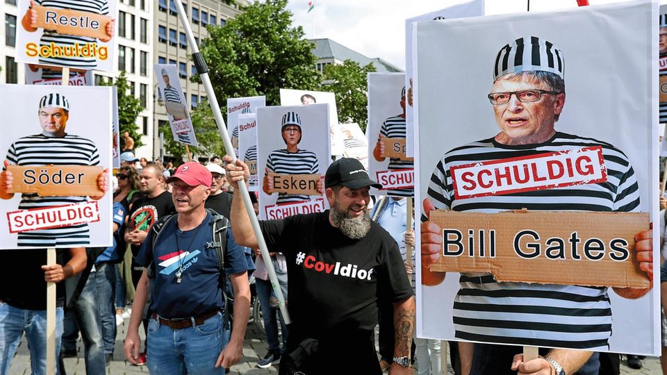 Demonstranten demonstrieren gegen Corona-Richtlinien mit Plakaten