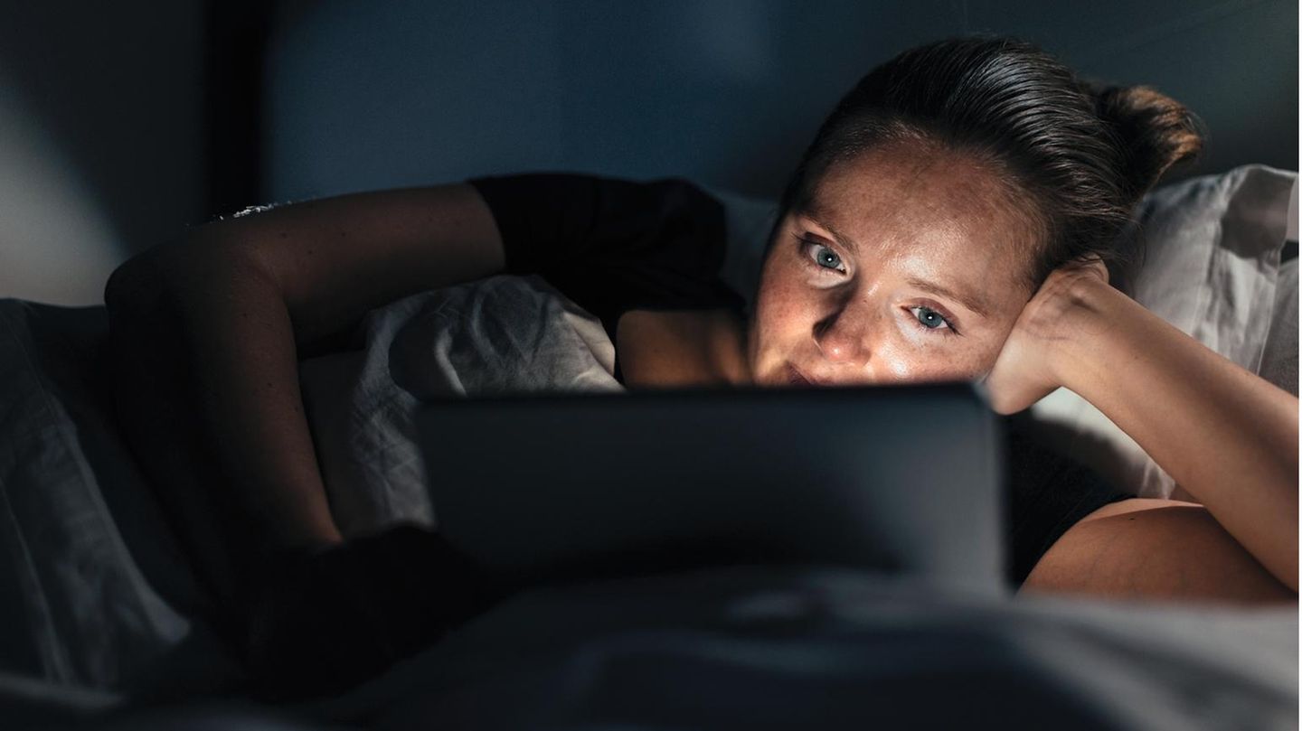 Woman using tablet pc, watching a movie late in the evening. Entspannt zu Hause Filme gucken: Die Corona- Pandemie verändert Sehgewohnheiten. Und das Geschäftsmodell der Branche
