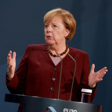 Kanzlerin Angela Merkel spricht mit ausgebreiteten Armen
