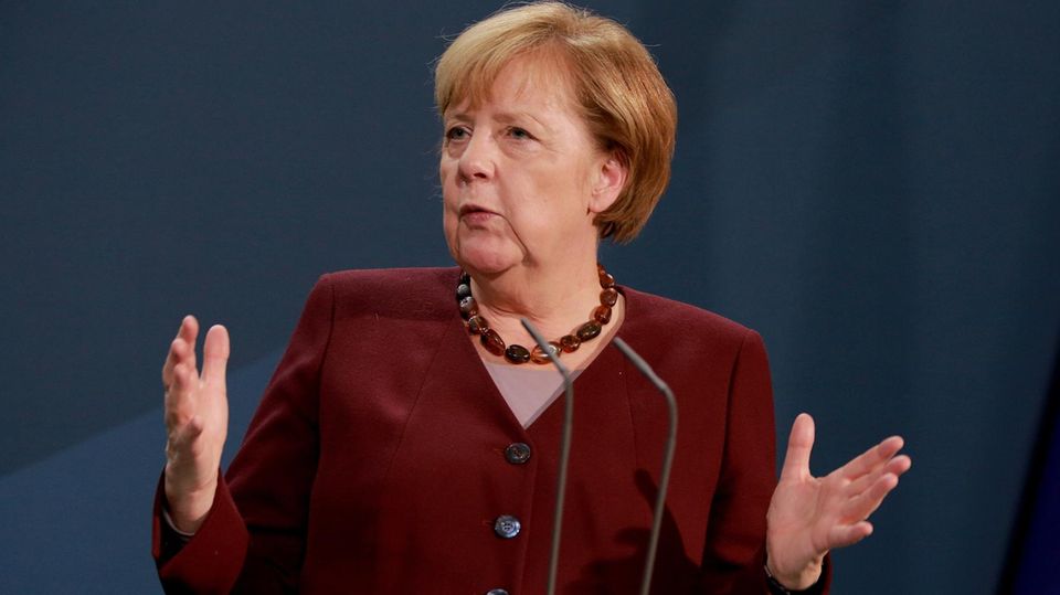 Kanzlerin Angela Merkel spricht mit ausgebreiteten Armen