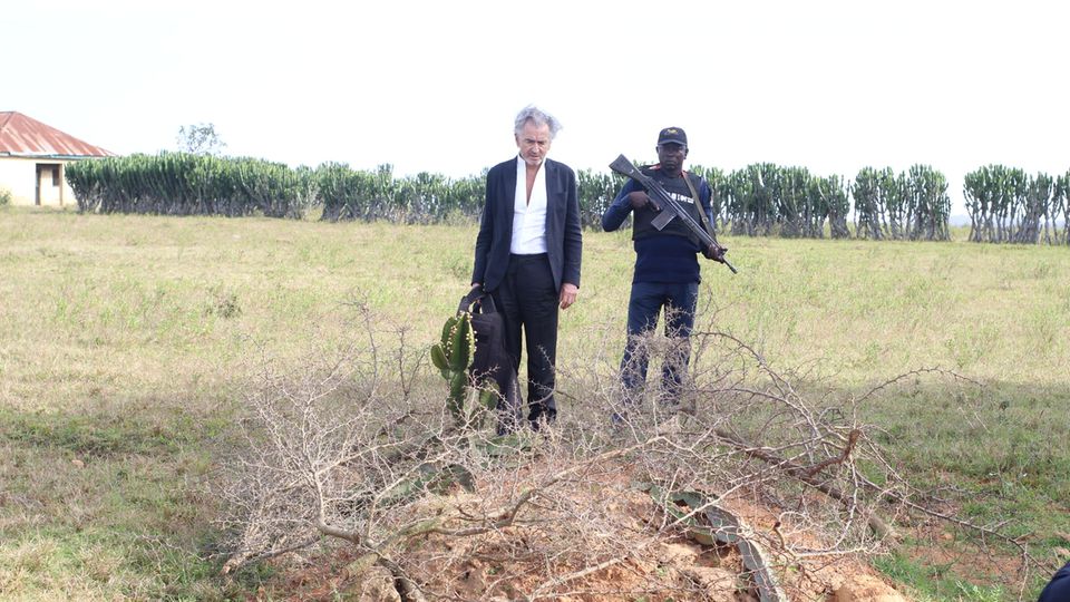 Bernard-Henri Lévy und sein Begleiter vor einem Grab in Tanjol, Nigeria