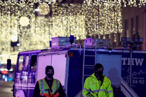 Zwei Polizisten und THW-Lkw vor der weihnachtlich geschmückten Altstadt von Trier