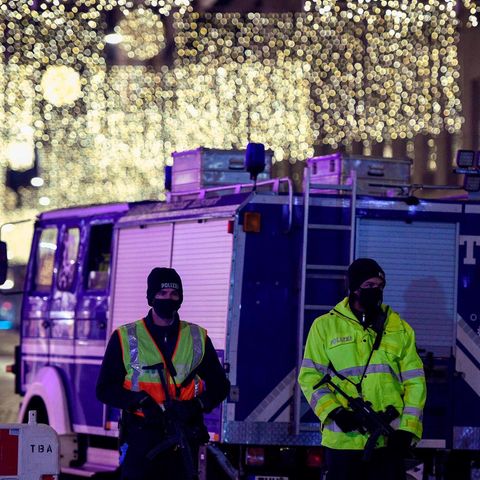 Zwei Polizisten und THW-Lkw vor der weihnachtlich geschmückten Altstadt von Trier