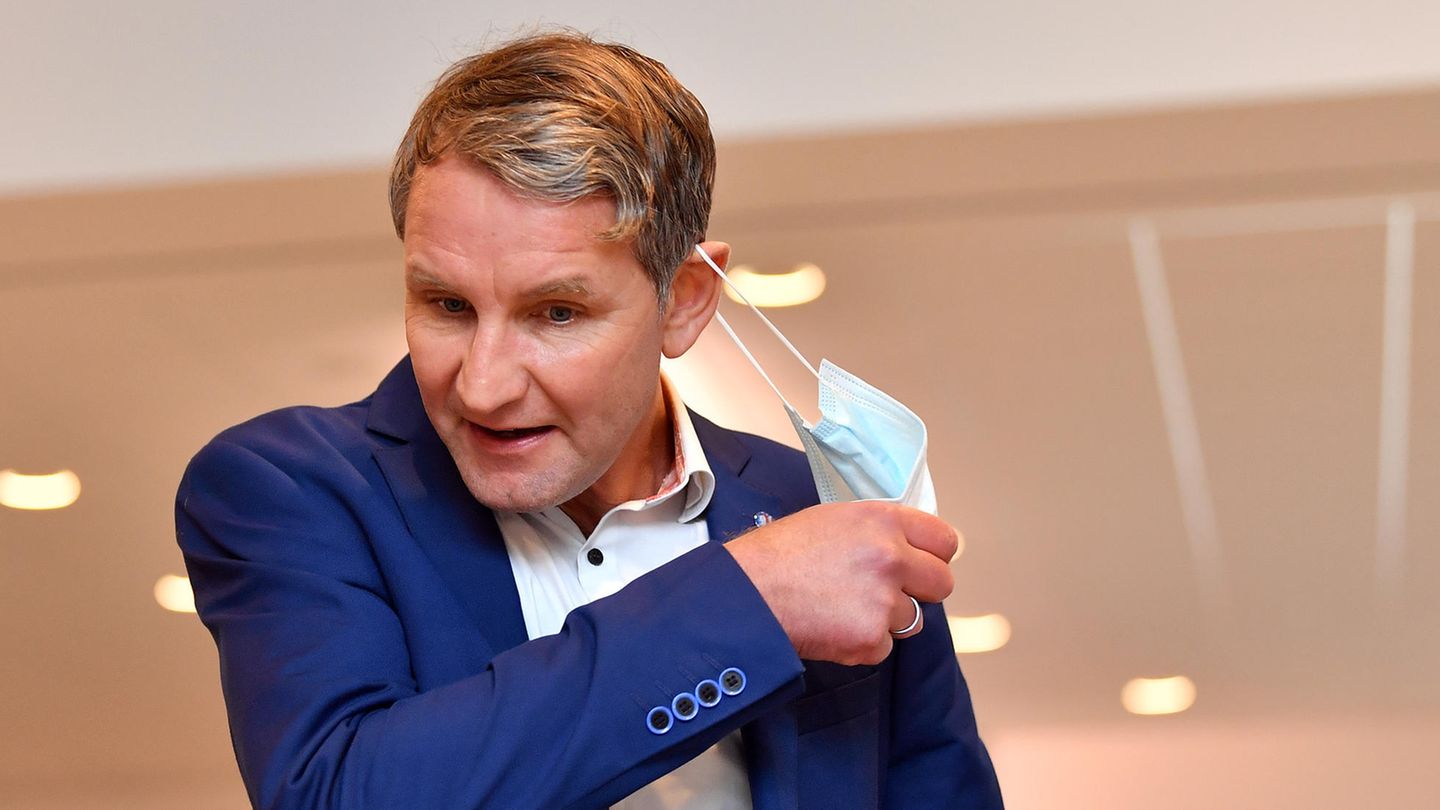 AfD-Politiker Höcke zieht sich eine Maske vom Gesicht