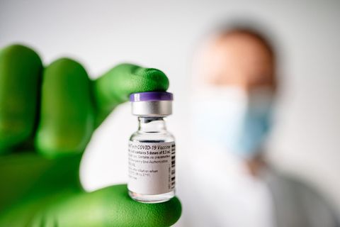 Ein Mitarbeiter des Mainzer Unternehmens Biontech hält ein Fläschen mit Corona-Impfstoff in der Hand