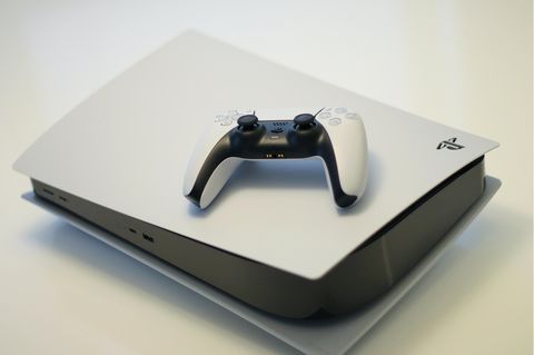 Eine Playstation 5 mit einem Controller liegt auf einem Tisch