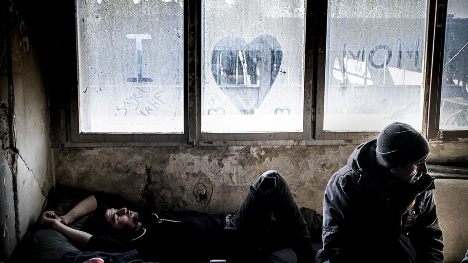 Reportage Bosnien Sayeed (l.) kommt aus Afghanistan. An das einzig verbliebene Fenster in der verfallenen Metallfabrik von Bihac hat er einen Gruß an seine Mutter geschrieben. Wenn sie telefonieren sagt er ihr, dass alles gut sei