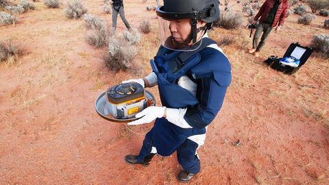 Ein Mitarbeiter der Japan Aerospace Exploration Agency (Jaxa) hält die kostbare Fracht in Händen