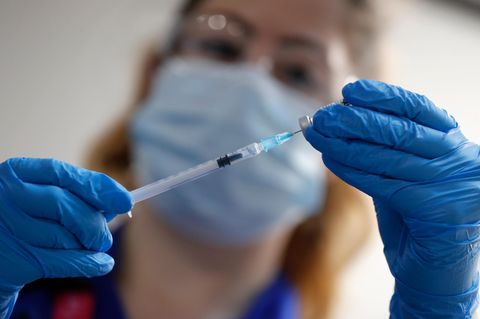 Eine Krankenpflegerin mit einer Spritze des Corona-Impfstoffs