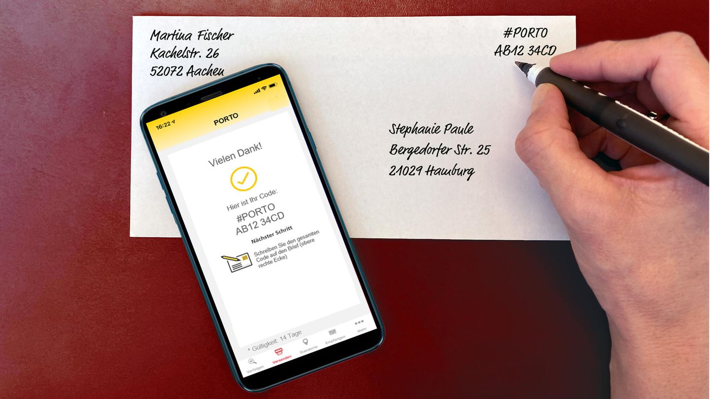 Eine Hand, die einen in der "Post & DHL"-App generierten Porto-Code auf einen Briefumschlag schreibt
