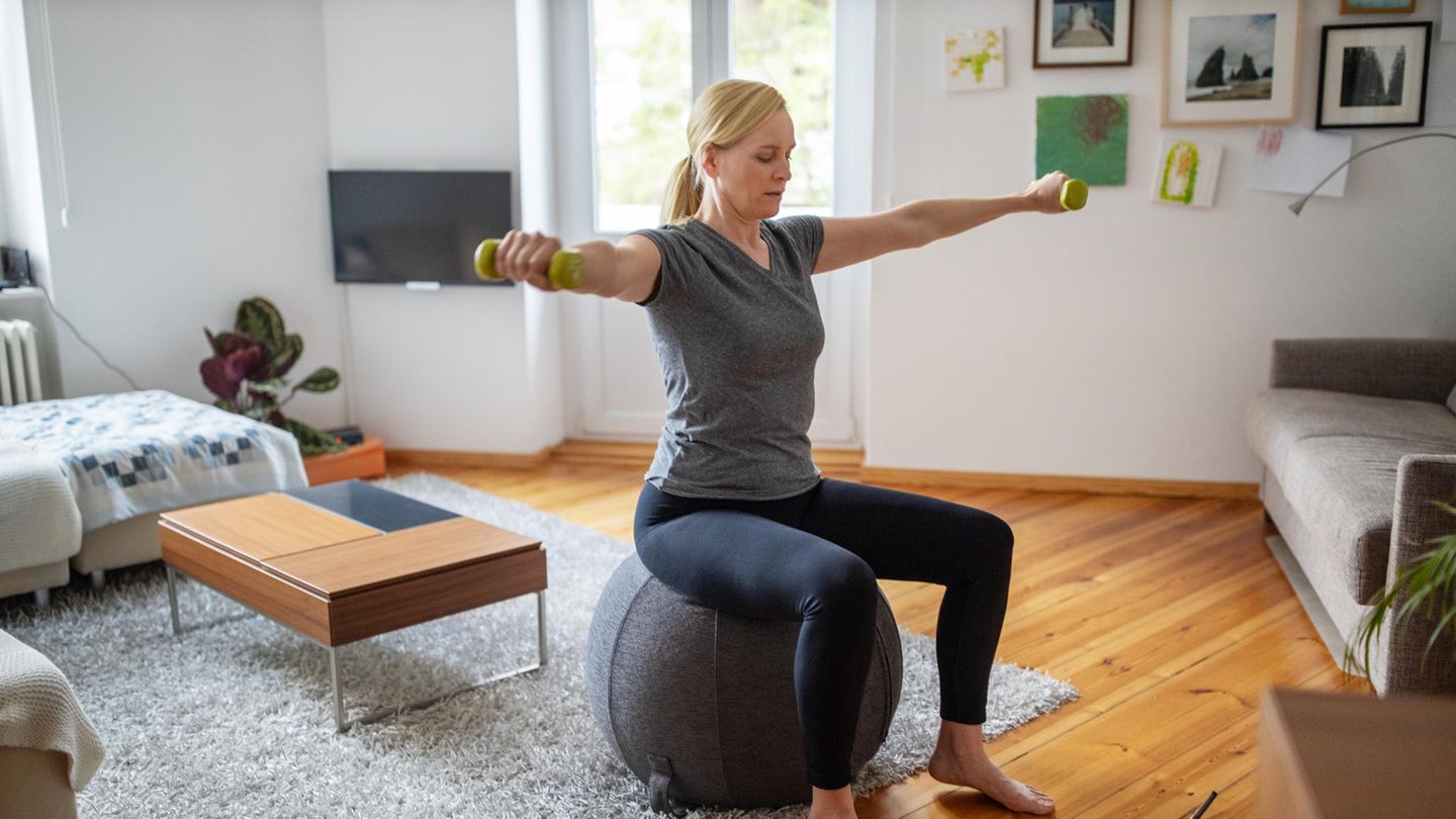 Sport Ausreden Frau macht Sport im Wohnzimmer mit Gymnastikball