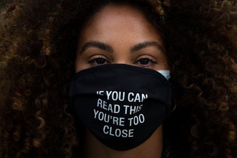 Frau trägt eine Schutzmaske mit der Aufschrift "If you can read this you're too close"