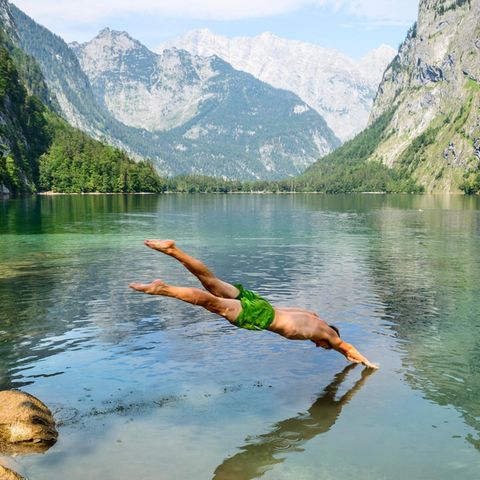 man springt mit Kopfsprung in den Obersee in Bayern