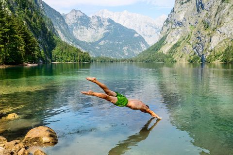 man springt mit Kopfsprung in den Obersee in Bayern