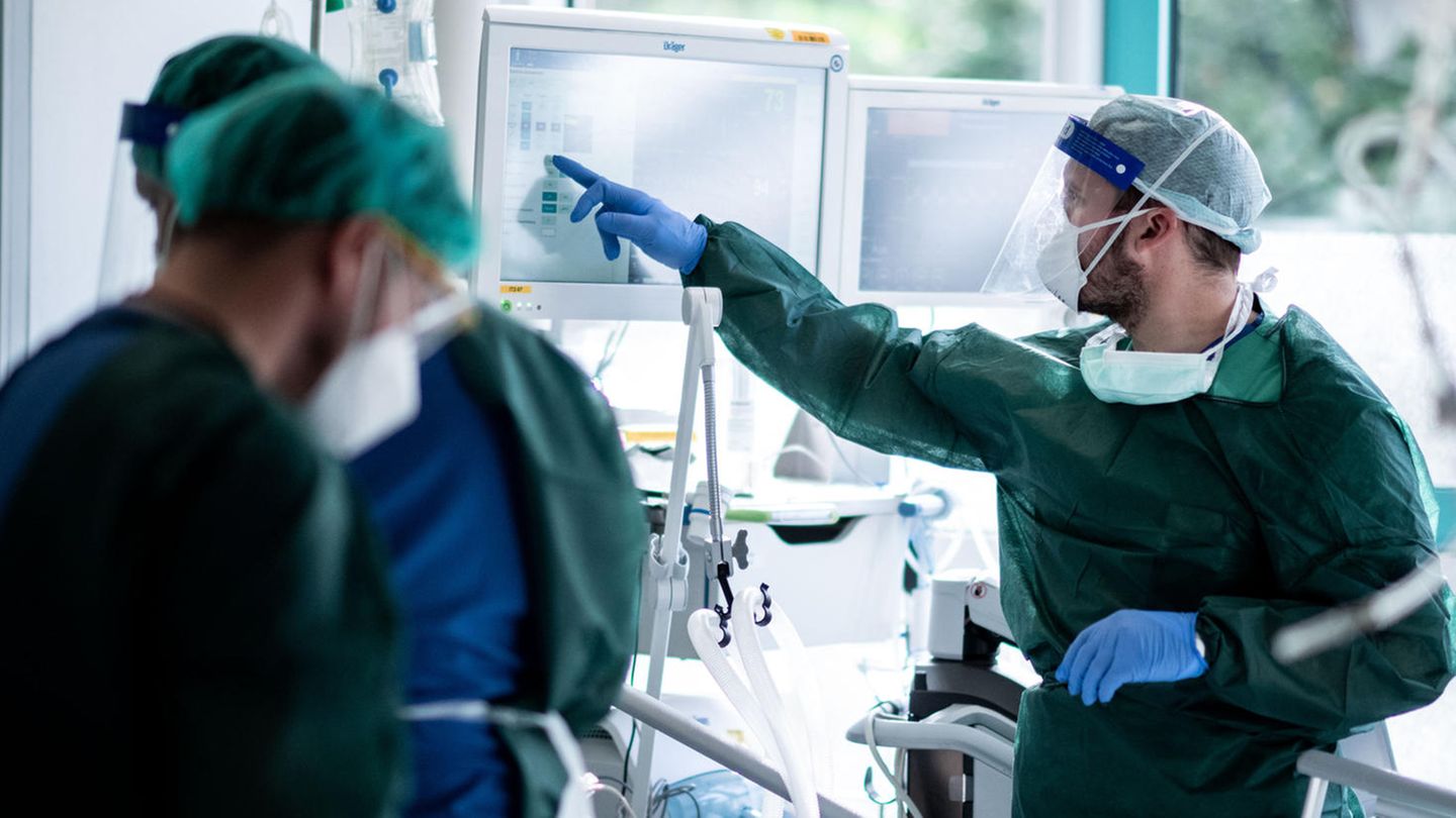 Mitarbeiter der Pflege behandeln einen Patienten mit Coronainfektion auf der Intensivstation im Universitätsklinikum Essen