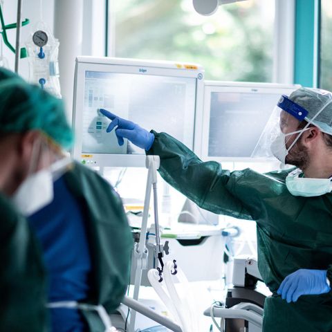 Mitarbeiter der Pflege behandeln einen Patienten mit Coronainfektion auf der Intensivstation im Universitätsklinikum Essen