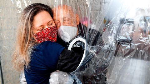 Brasilien - „Kuschelkontakt“ und „Umarmungs-Gardine“ sind Worte, die es erst seit diesem Jahr gibt. Die Plastikfolie macht es möglich, dass Maria  Paula Moraes ihren 82-jährigen Vater Wanderley im Juli das erste Mal nach 100 Tagen wieder spüren kann.