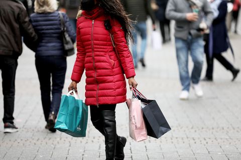 Nordrhein-Westfalen, Köln: Eine Frau geht mit Einkaufstaschen durch die Fußgängerzone