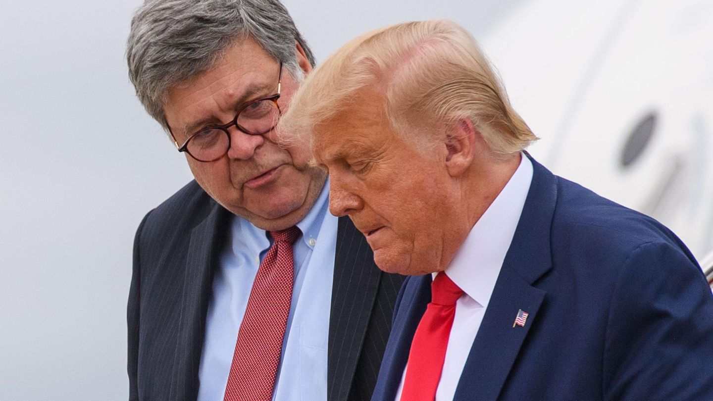 William Barr schaut Donald Trump (r.) an