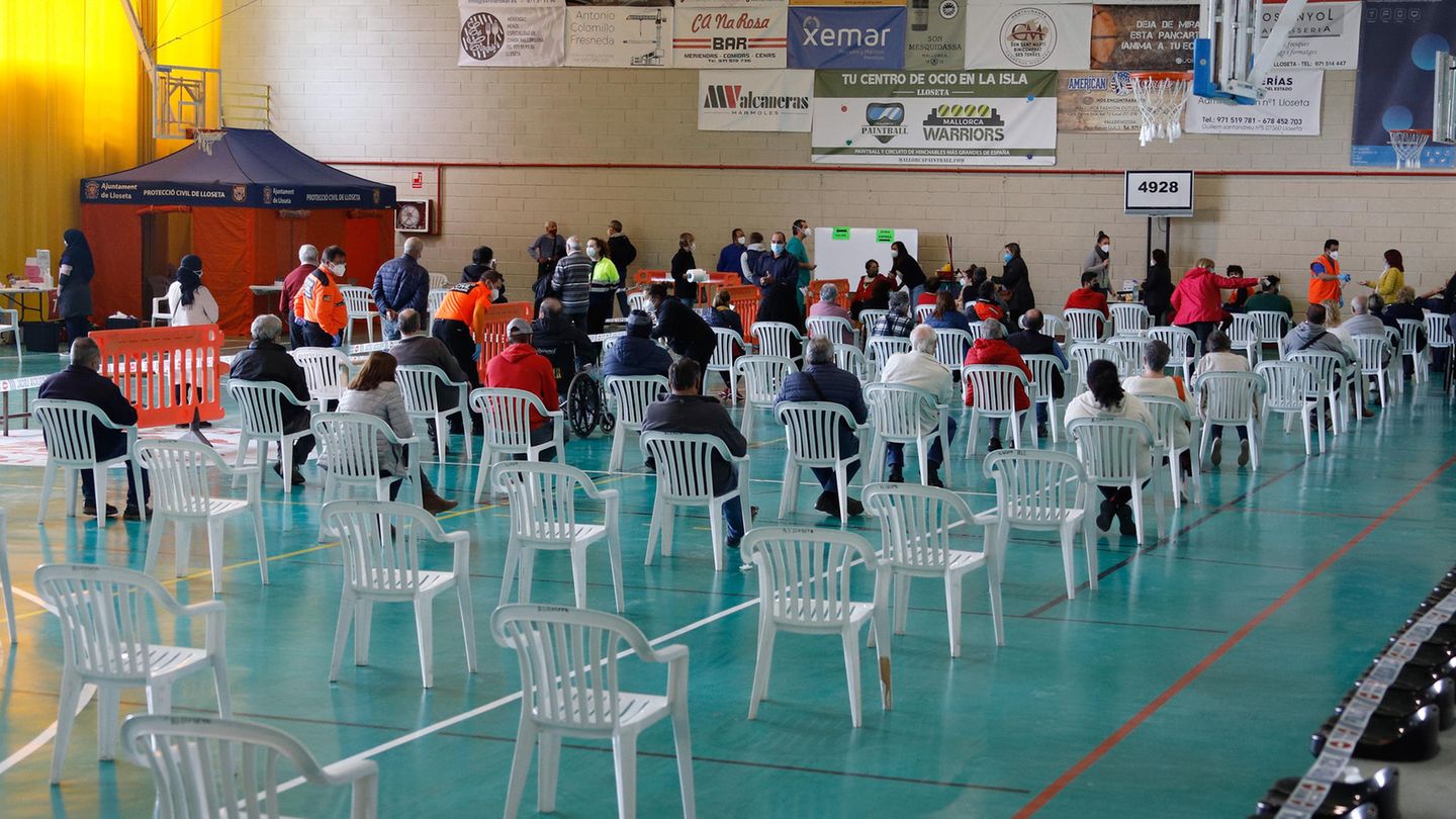 Menschen warten in einer Sporthalle in Lloseta auf Mallorca darauf, auf Covid-19 getestet zu werden. Die Regierung der Balearen führt nach der Zunahme der Infektionen mit dem Coronavirus massive Tests an der Bevölkerung durch.