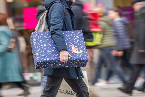 Eine Person trägt ein Weihnachtsgeschenk