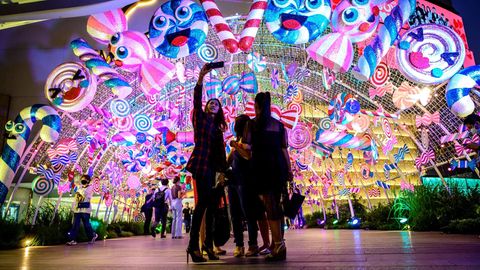 Bangkok: Selfie bei Weihnachts-Shopping  Am Eingang eines Einkaufzentrum machen diese jungen Thailänderinnen ein Foto mit der über ihnen strahlenden Fantasie-Deko.