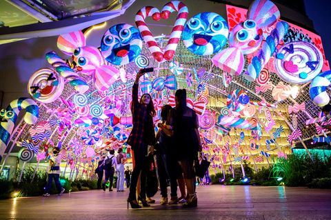 Bangkok: Selfie bei Weihnachts-Shopping  Am Eingang eines Einkaufzentrum machen diese jungen Thailänderinnen ein Foto mit der über ihnen strahlenden Fantasie-Deko.