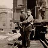 Der Bahnschaffner scheint keinen Anstoß an der Umarmung dieser beiden Männer zu nehmen, die sich geradezu überschwänglich aneinander klammern. Die Aufnahmen zeigen oft Cowboys, Soldaten oder Arbeiter - Berufe, in denen fast ausschließlich Männer anzutreffen waren. Dass sie ihre Zuneigung zueinander öffentlich bekundeten war deshalb nichts Ungewöhnliches.