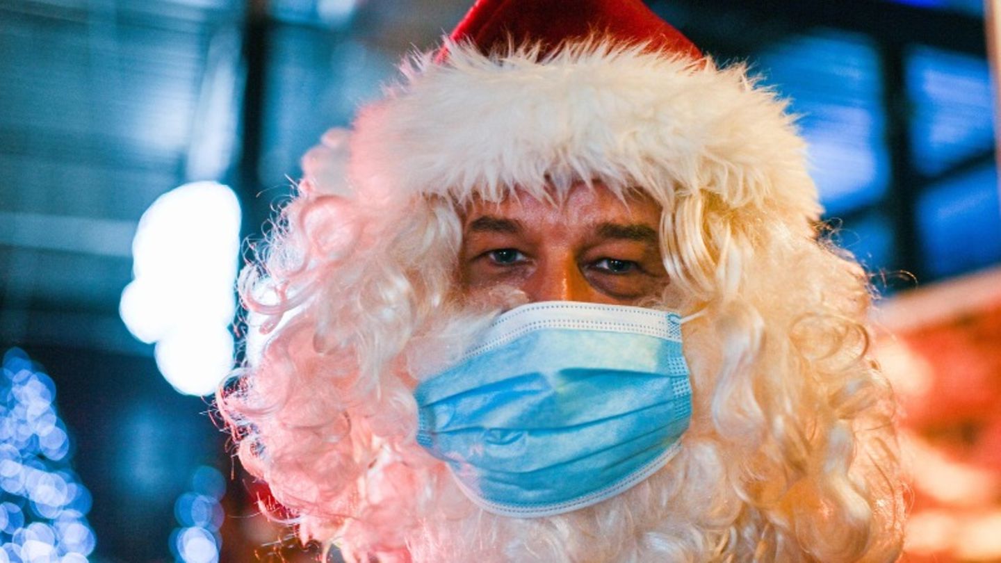 Ein als Weihnachtsmann verkleideter Mann mit einem Mund-Nasen-Schutz