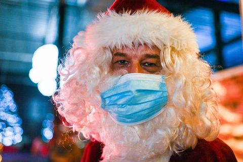 Ein als Weihnachtsmann verkleideter Mann mit einem Mund-Nasen-Schutz