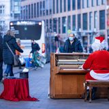 Schwerin: Weihnachtslieder in der Fußgängerzone  Kurz vor dem zweiten Lockdown: Ein als Weihnachtsmann verkleideter Straßenmusikant spielt in der Innenstadt auf seinem mobilen Klavier.