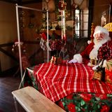 Los Angeles: Mit Plexiglas geschützt  Ein als Weihnachtsmann verkleideter Mann sitzt aufgrund der Ansteckungsgefahr mit dem Coronavirus hinter Plexiglaswänden in einem Raum in den "Citadel Outlets".