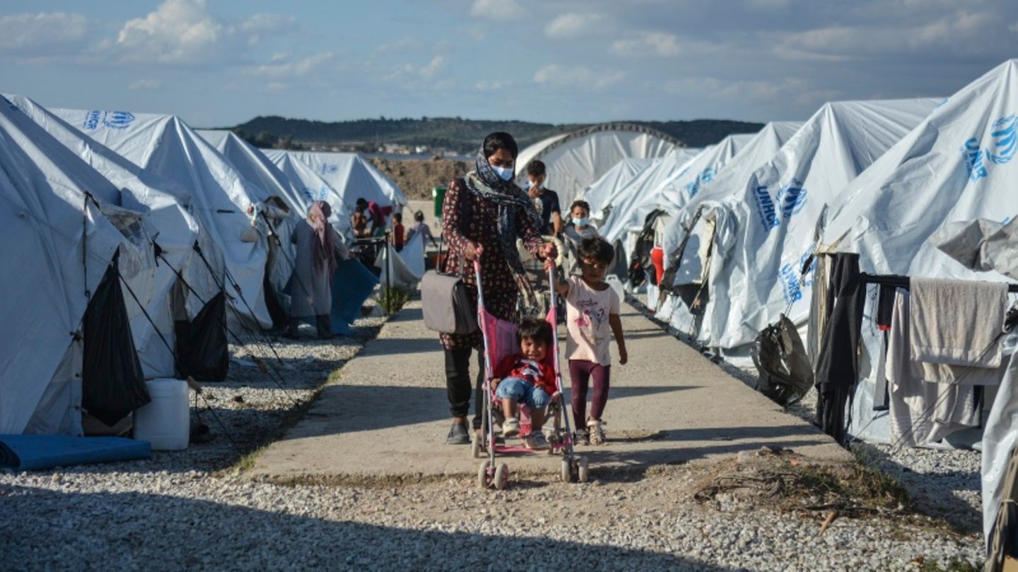 Eine Familie läuft im Camp Kara Tepe zwischen den Zelten