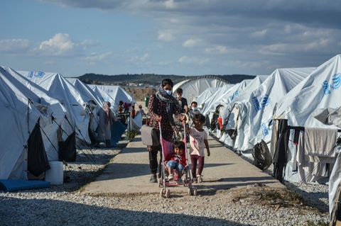 Eine Familie läuft im Camp Kara Tepe zwischen den Zelten