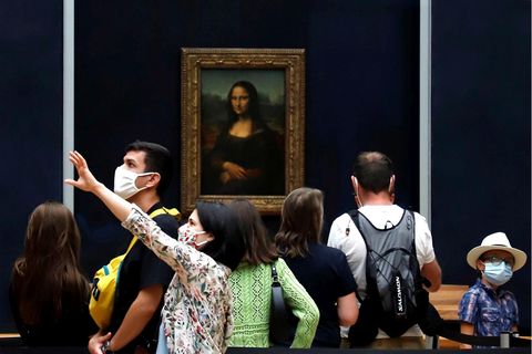 Besucher tragen Mundschutze während sie im Museum Louvre Leonardo da Vincis Meisterwerk "Mona Lisa" betrachten