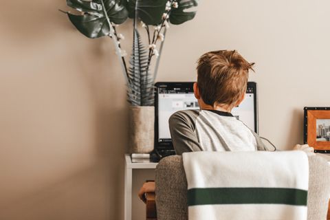 Ein Junge sitzt vor seinem heimischen Computer, um digitalen Unterricht mitzumachen