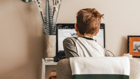 Ein Junge sitzt vor seinem heimischen Computer, um digitalen Unterricht mitzumachen