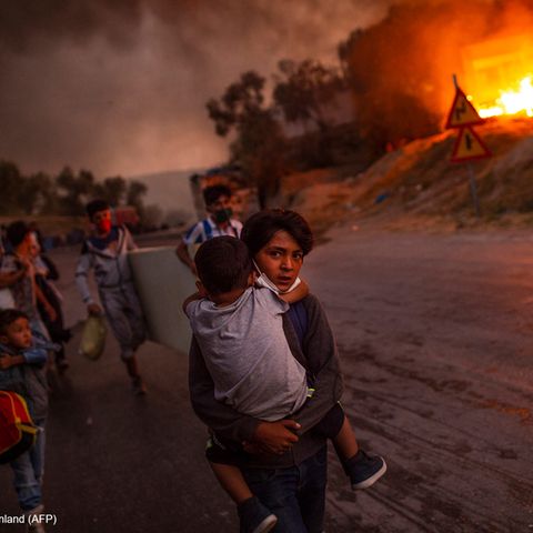 Lesbos, Griechenland: Am 9. September 2020 zerstört im Flüchtlingslager Moria auf der griechischen Insel Lesbos ein Feuer die Unterkünfte von 13.000 Menschen, darunter 4.000 Kinder. Sie sind von Krieg und Gewalt geflohen. Sie haben unter elenden Bedingungen ausgeharrt, viele seit Jahren. Das Lager ist überfüllt, Krankheiten grassieren, immer wieder werden Lebensmittel und sauberes Wasser knapp. Und nun das Feuer. Es breitet sich rasend schnell aus, den Flüchtlingen bleibt nur, in die Hand zu nehmen, was sie greifen können. Unter den vielen Bildern von dieser Inferno-Nacht hat der griechische Fotograf Angelos Tzortzinis die eindrucksvollsten vom Leiden der Kinder gemacht. Und jenes Foto, das alles gleichzeitig zeigt: Flucht und Tapferkeit, Fassungslosigkeit und Hilfsbereitschaft in höchster Not. Die Stärke des Kleinen, der dem noch Kleineren die heile Haut bewahrt. Unter den nach UNO-Schätzungen gegenwärtig rund 79,5 Millionen Menschen auf der Flucht sind etwa 32 Millionen Kinder und Jugendliche.   Angelos Tzortzinis, geboren in Athen, hat an der Leica Academy of Creative Photography studiert und seither überwiegend als freier Fotograf gearbeitet. Er hat aus Georgien berichtet und vom Erdbeben in Haiti 2010, vom "Arabischen Frühling" in Kairo und dem Krieg in Libyen. Vor allem aber beschäftigt ihn die Situation der Flüchtlinge in seinem Heimatland.
