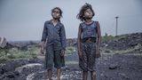 Indien: Die Kohlefelder von Jharia im Bundesstaat Jharkhand gehören zu den größten in ganz Asien. Auf 280 Quadratkilometern wird hier Kohle im Tagebau gewonnen. Es ist das Land der schwarzen Gesichter. Giftiges Land, denn seit über 100 Jahren steigen hier aus ungezählten unterirdischen Feuern toxische Gase auf: Schwefeldioxid, Kohlenmonoxid. Luft und Trinkwasser sind verschmutzt, Asthma, Tuberkulose und Hautkrankheiten grassieren. Trotzdem halten es Menschen hier aus, ziehen sogar auf der Suche nach Arbeit hierher. Und auch Kinder arbeiten in den offenen Minen, schleppen Steine. Der indische Fotograf Supratim Bhattacharjee hat in den Gesichtern dieser Kinder ihr ganzes Elend eingefangen, Entsetzen, Erschöpfung, Zerstörung. Die Eltern sind meist Analphabeten. Der Tageslohn, umgerechnet ein bis zwei US-Dollar, in den oft illegal betriebenen Minen am Rande der großen Kohlefelder ist derart gering, dass schon Vier-, Fünf-, Sechsjährige zur Mitarbeit gezwungen sind. Viele Mädchen und Jungen sind mangelernährt; zur Schule gehen sie nicht.  Supratim Bhattacharjee wurde 1983 in Boraipur bei Kalkutta geboren und hat für Filmproduktionen gearbeitet, bevor er Fotograf wurde. Umwelt- und Menschenrechtsthemen stehen in seinem Fokus, vor allem aber beschäftigt ihn die sozio-ökonomische Situation in seinem Heimatland. Die Kinder von Jharia zu erleben, schreibt Bhattacharjee, hätte ihn nicht nur geschmerzt. Sie seien "ein Schock" für ihn gewesen.