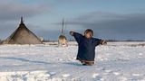 Russland: Sie werden in der Kälte geboren, wachsen in Zelten auf, ziehen mit ihren Eltern auf Schlitten umher, von Rentieren gezogen: Die Kinder der Nenzen, einem der 44 indigenen Völker auf russischem Territorium, wachsen in großer Freiheit auf. Als Nomaden im äußersten Nordwesten Russlands. Weder eine Heizung noch Elektrizität kennen die Kinder; Wasser wird aus geschmolzenem Schnee gewonnen, Strom liefert zwei bis drei Stunden am Tag ein Generator. Aber dann, wenn sie sieben Jahre alt sind, landen Helikopter, um die Nenzen-Kinder in eine zentrale Schule zu bringen. Für neun Monate jedes Jahr. Bis sie 17 sind. Das alles ist kostenfrei. Und doch ungewohnt für die Kinder, die zunächst kein Russisch sprechen und sich zwischen zwei Kulturen zu orientieren haben. Die Fotografin Elena Chernyshova hat die Kinder der Rentierzüchter in beiden Leben begleitet: in der Tundra und in der Stadt; eingepackt in Felle und beim Turnen in der Schule; unter dem großen Himmel – und unter Beobachtung der Lehrer.  Chernyshova, 1981 in Moskau geboren, hat ihr Interesse an der Fotografie während des Studiums an einer Architektur-Akademie entdeckt. Ihre Reportage über die Nenzen-Kinder ist im "stern" erschienen. Zu Chernyshovas Auszeichnungen gehört ein World Press Photo Award.