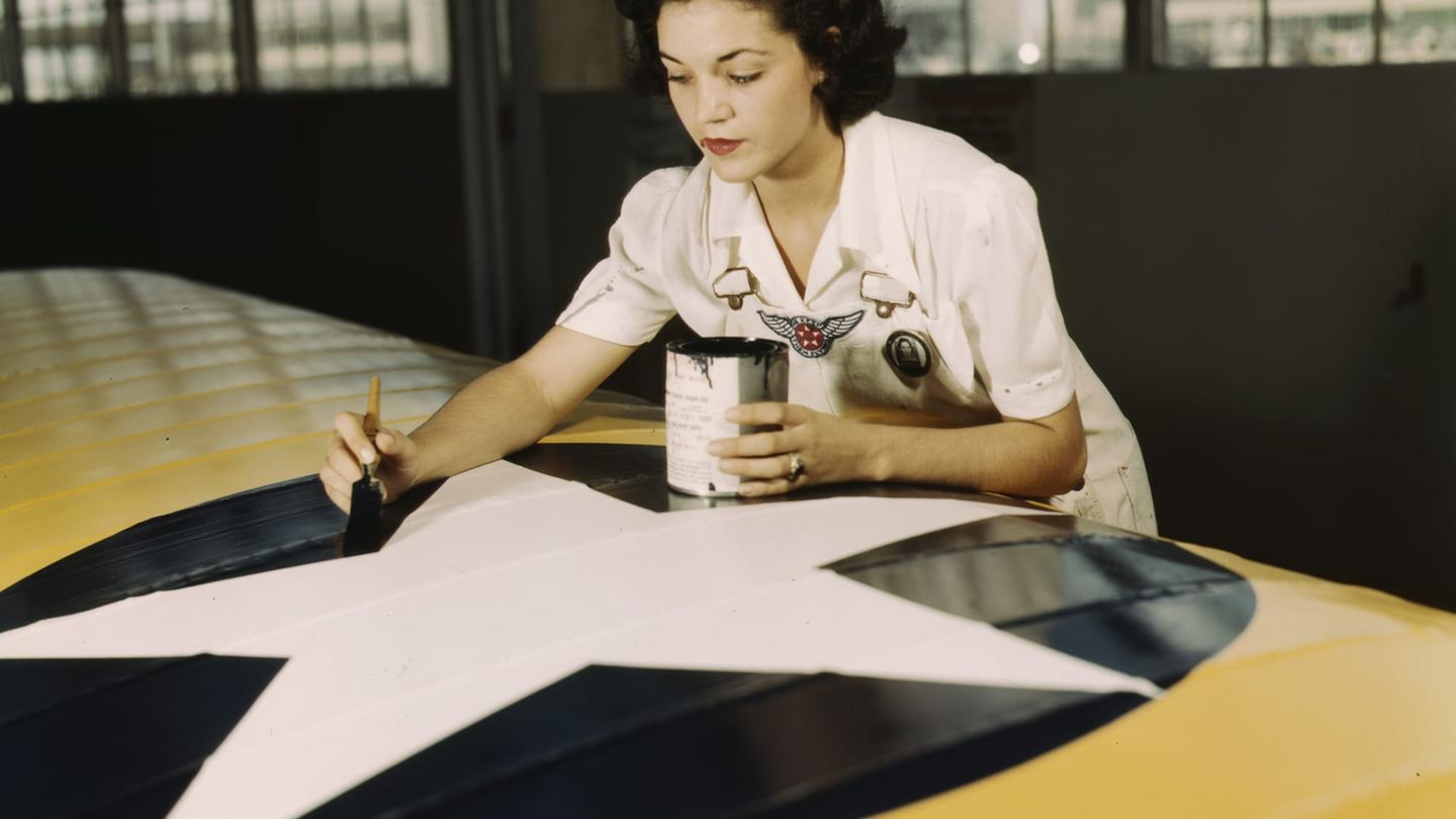 Irma Lee McElroy pinselt die Hoheitsabzeichen der USA auf einen Flügel.