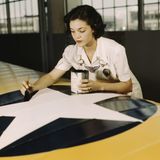 Irma Lee McElroy pinselt die Hoheitsabzeichen der USA auf einen Flügel.