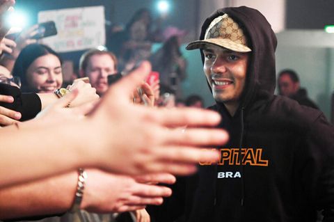 Rapper Capital Bra bei einem Konzert, umringt von Fans