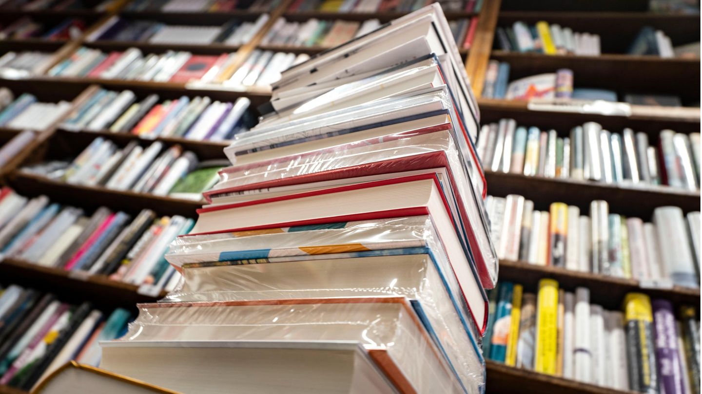 Ein Stapel neuer Bücher liegt auf einem Verkaufstisch in einer Buchhandlung