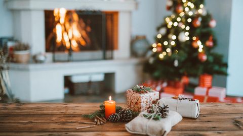 Geschenke liegen auf dem Tisch, im Hintergrund ein Weihnachtsbaum