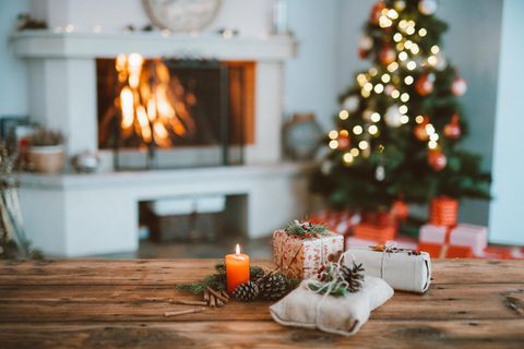 Geschenke liegen auf dem Tisch, im Hintergrund ein Weihnachtsbaum