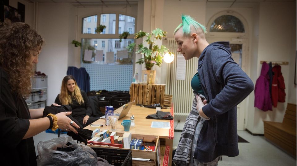 Praktikantin Anne (l.) und Streetworkerin Vici suchen passende Kleidung für Toni (r.) Praktikantin Anne (l.) und Streetworkerin Vici suchen passende Kleidung für Toni (r.)